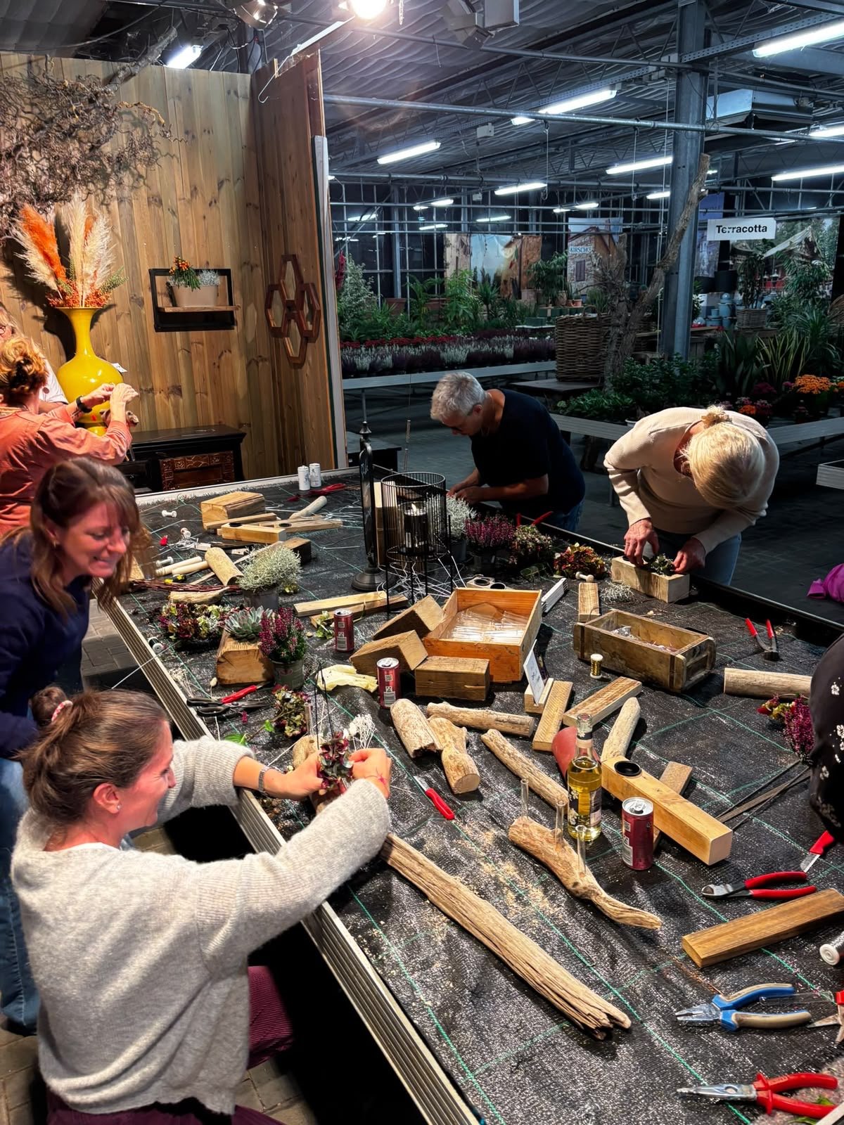 Teilnehmende beim Gestalten am Werktisch